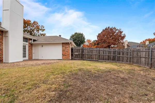 a view of backyard and wooden fence