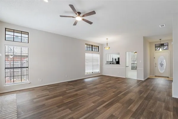 a view of a kitchen with wooden floor and a ceiling fan