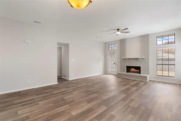 a view of empty room with wooden floor and fireplace