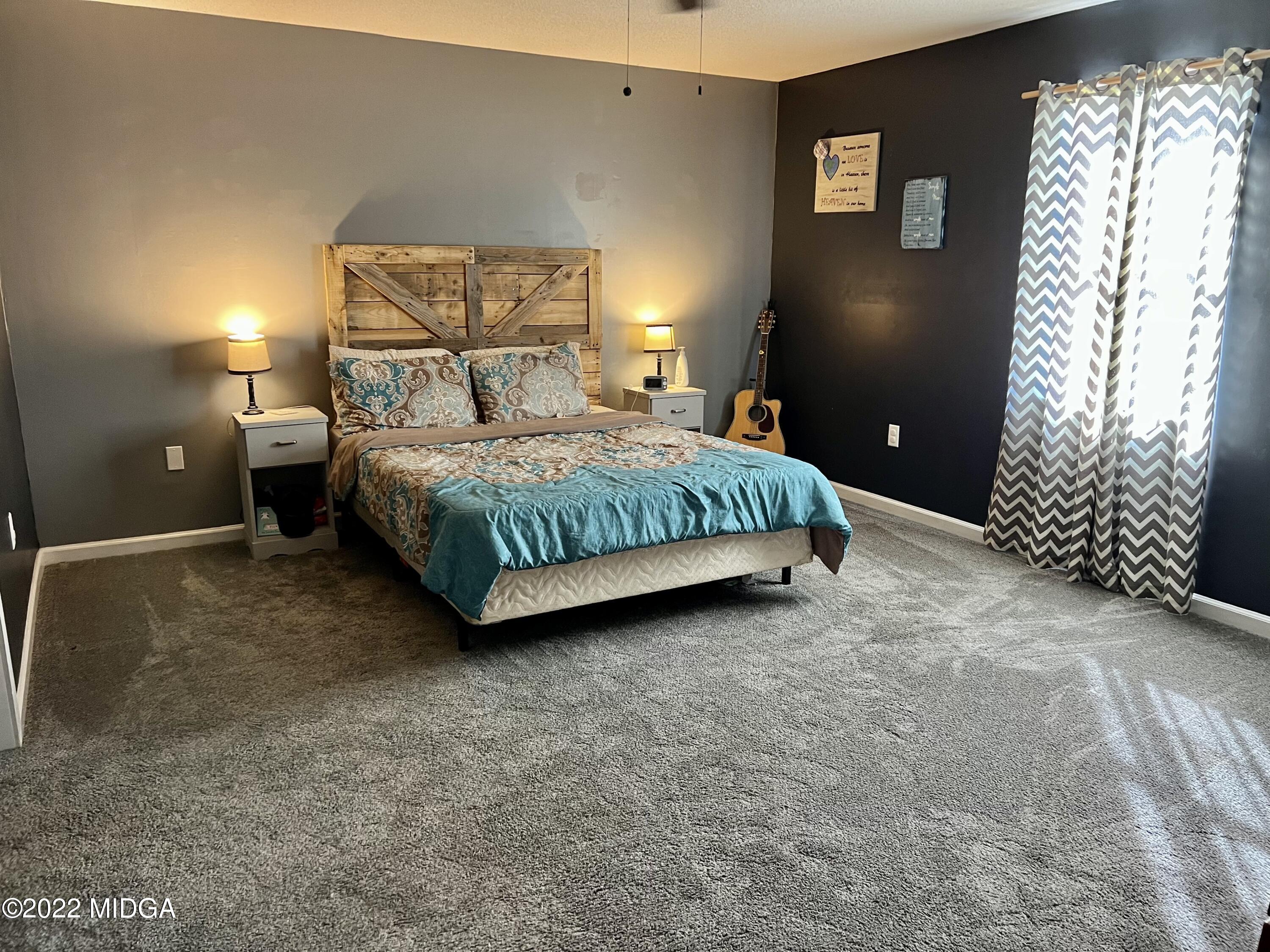1817 Union Church Road Fort Valley, GA 31030 - Photo 4 of 18 a spacious bedroom with a bed and a chandelier
