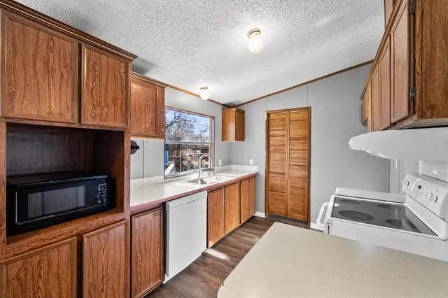 a kitchen with stainless steel appliances a stove a sink a microwave a refrigerator and cabinets