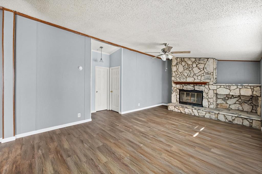 7634 Gibson Cemetery Road Mansfield, TX 76063 - Photo 5 of 11 a view of an empty room with wooden floor fireplace and a window