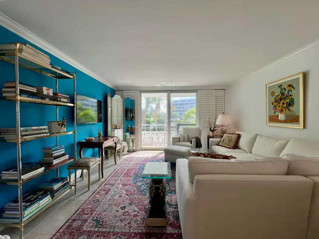 a living room with furniture a bookshelf and a window
