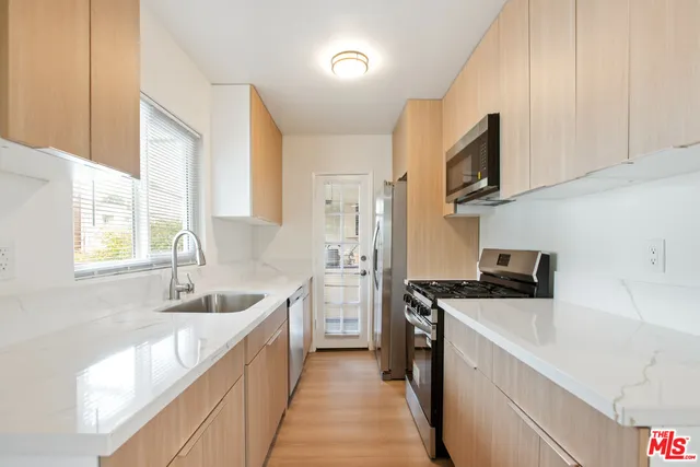 a kitchen with stainless steel appliances granite countertop a sink stove and refrigerator