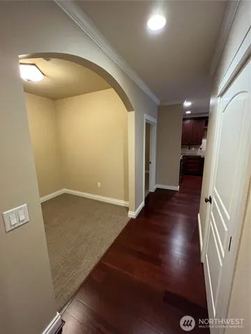 en empty room with wooden floor and entrance