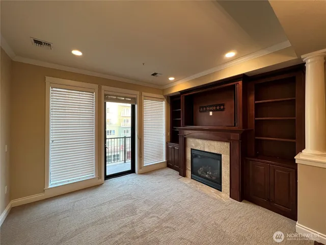 a view of an empty room with a fireplace and a window