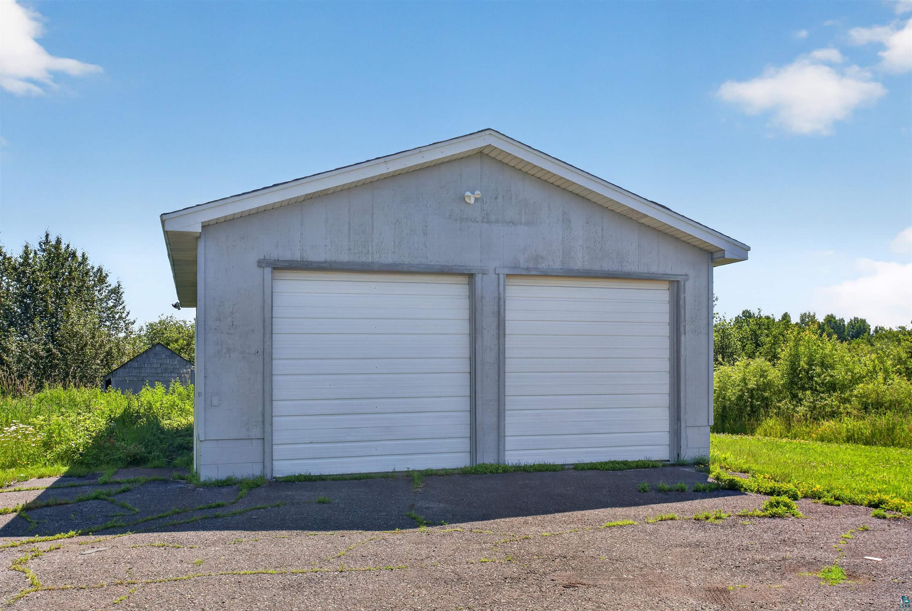 5868 Rice Lake Road Duluth, MN 55803 - Photo 29 of 39 Detached two-car garage featuring dual white overhead doors and a gabled roofline