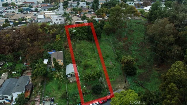 an aerial view of residential houses with outdoor space and trees
