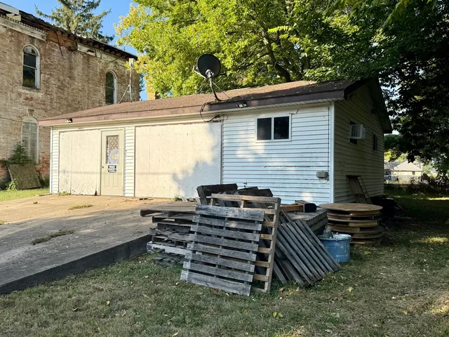 a backyard of a house with barbeque oven and outdoor seating