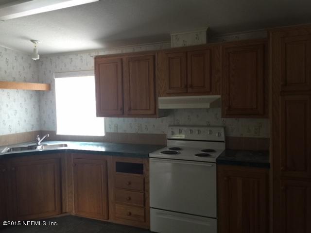217 Barco Road St. Augustine, FL 32080 - Photo 7 of 18 a kitchen with stainless steel appliances granite countertop a sink stove and cabinets