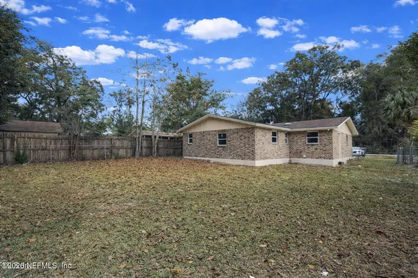 a backyard of a house with plants and tree