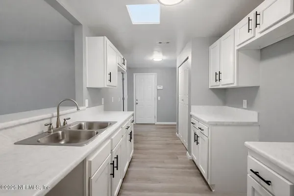 a kitchen with a sink stove top oven and cabinets
