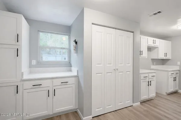a view of a kitchen with white cabinets