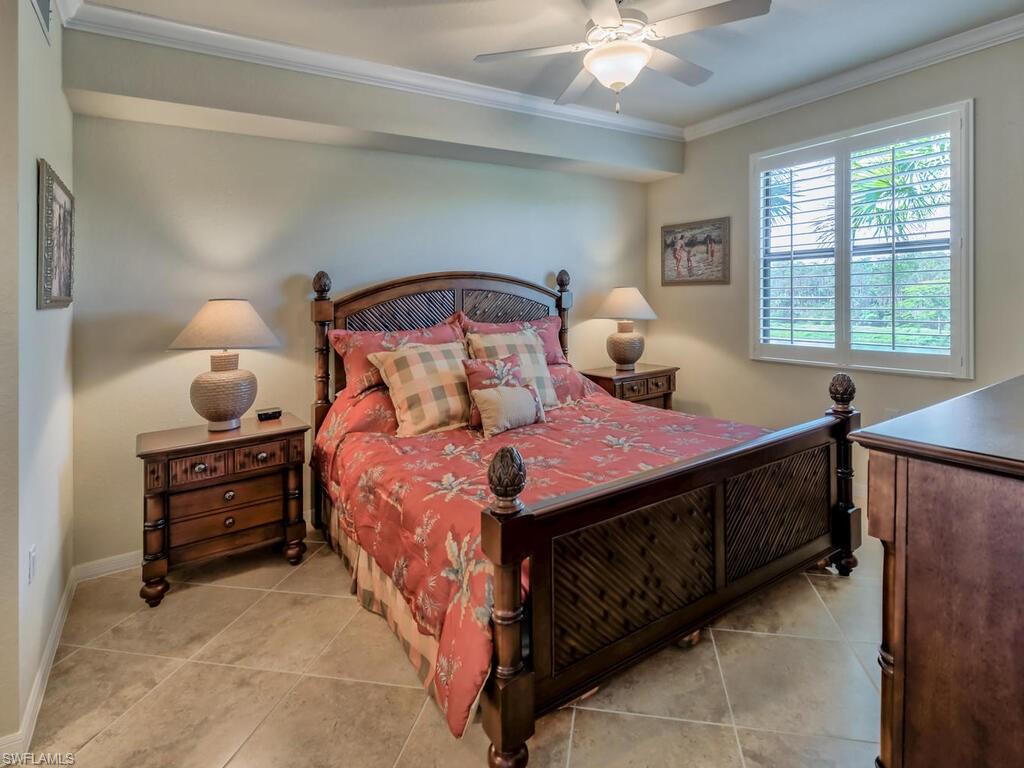 9735 Acqua Court, Unit 635 Naples, FL 34113 - Photo 1 of 33 a bedroom with a bed and a chandelier