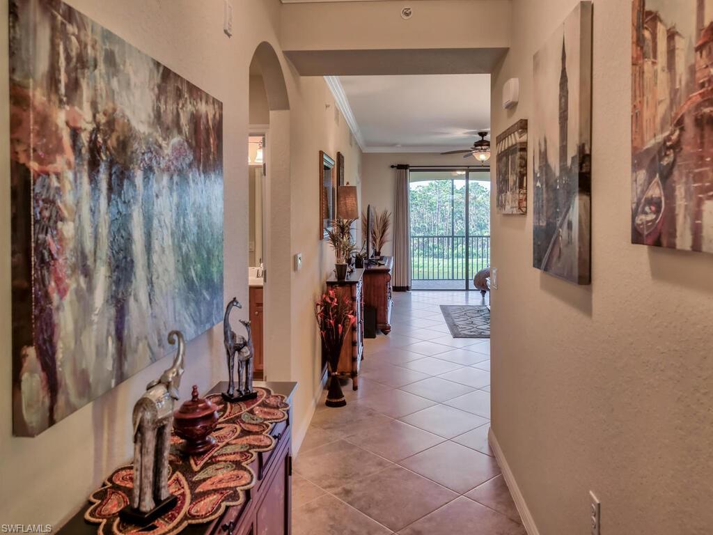 9735 Acqua Court, Unit 635 Naples, FL 34113 - Photo 4 of 33 a hallway with a stove a mirror and furniture