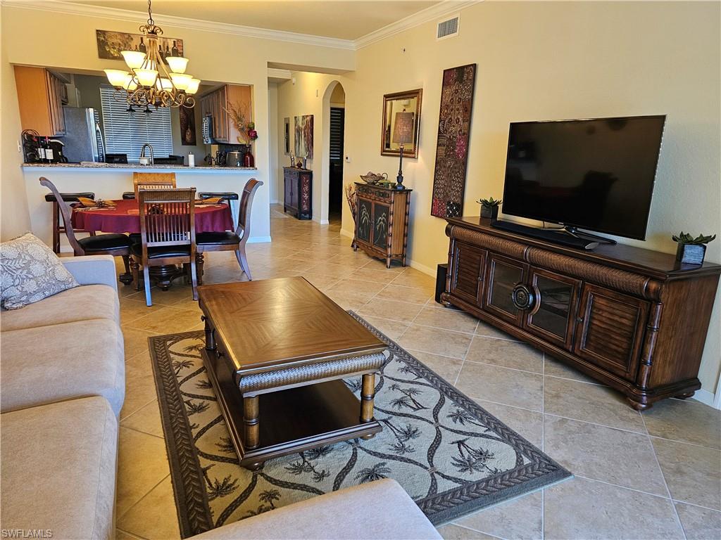 9735 Acqua Court, Unit 635 Naples, FL 34113 - Photo 7 of 33 a living room with furniture and a flat screen tv
