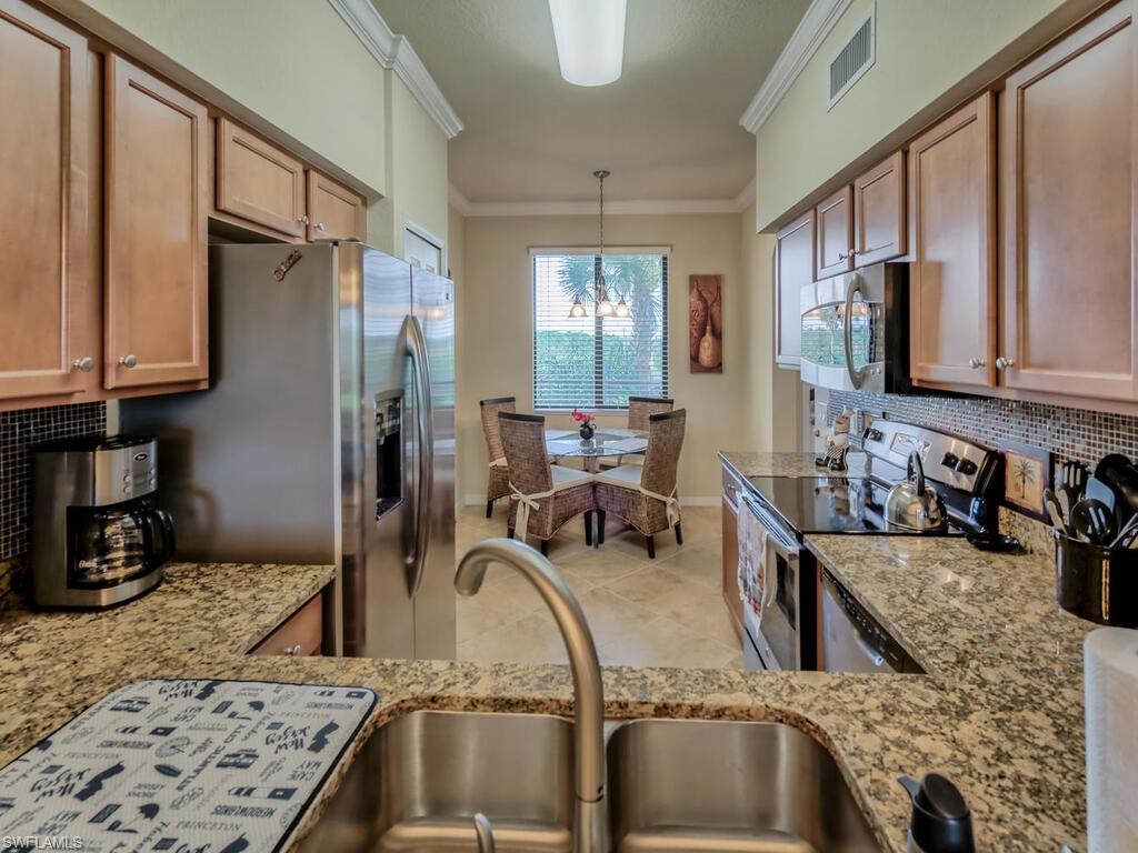 9735 Acqua Court, Unit 635 Naples, FL 34113 - Photo 8 of 33 a kitchen with stainless steel appliances granite countertop a sink refrigerator and cabinets