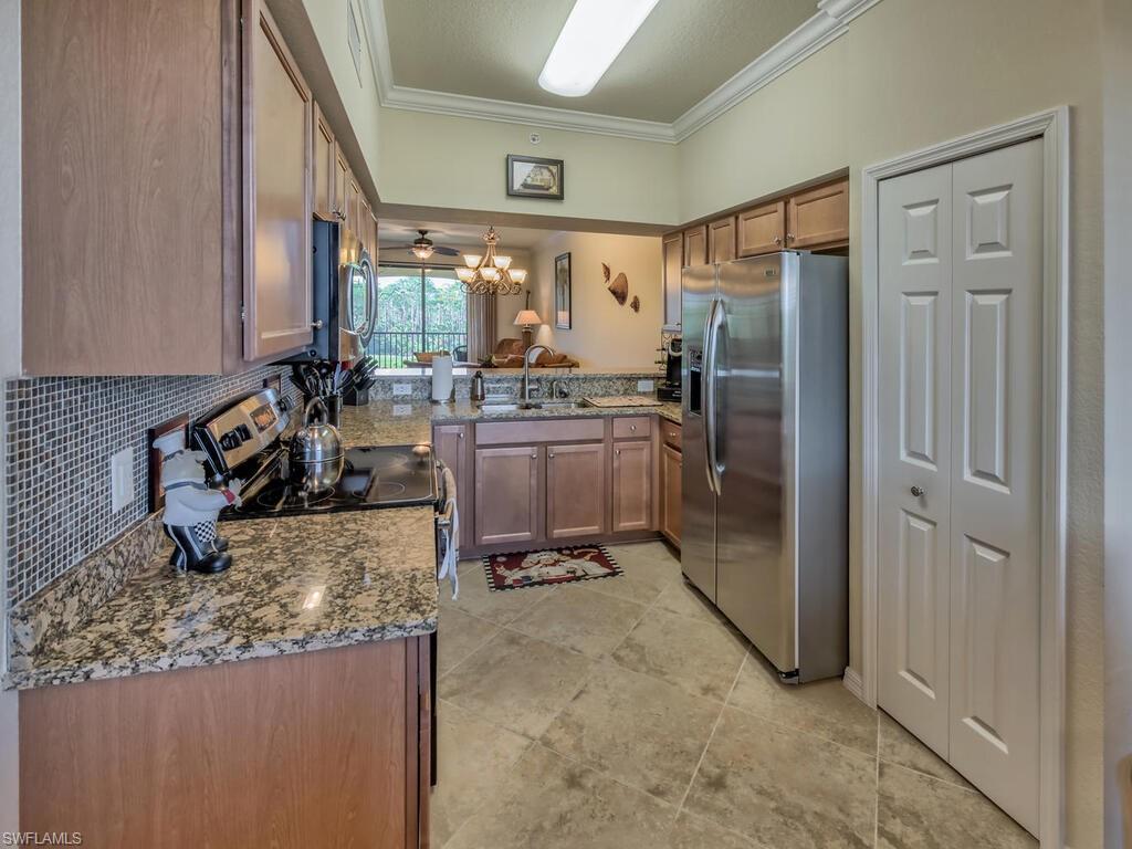 9735 Acqua Court, Unit 635 Naples, FL 34113 - Photo 9 of 33 a kitchen with a refrigerator and a sink