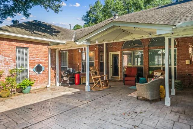 a view of a patio with table and chairs under an umbrella