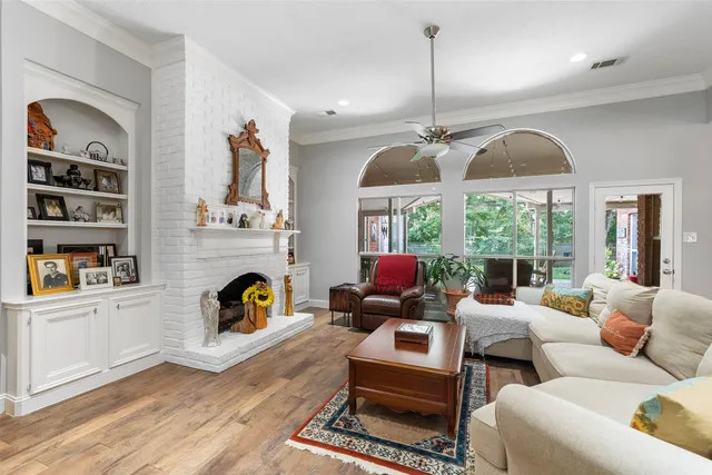 a living room with furniture fireplace and a large window