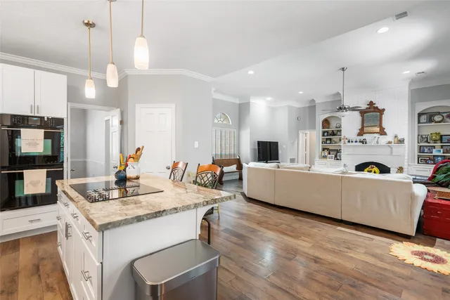 a large kitchen with kitchen island a large counter top space appliances and cabinets