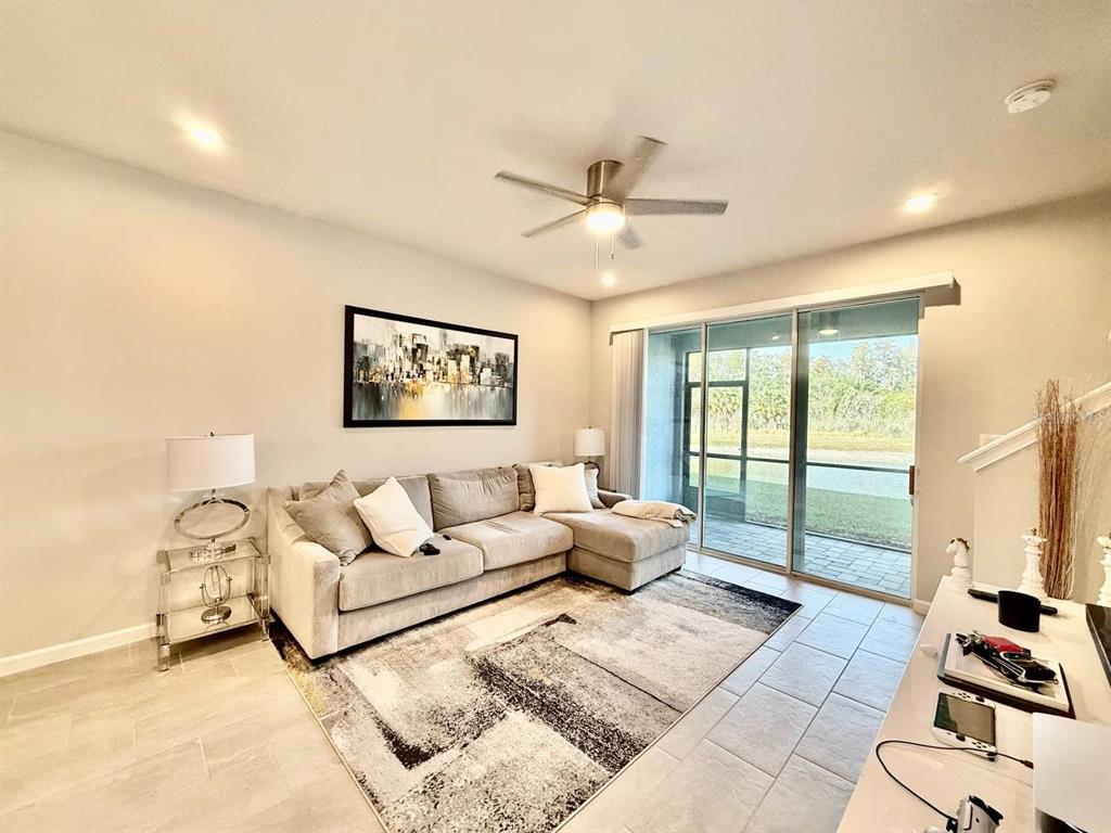 8319 Wildflower Glen Avenue Odessa, FL 33556 - Photo 11 of 34 a living room with furniture and a large window