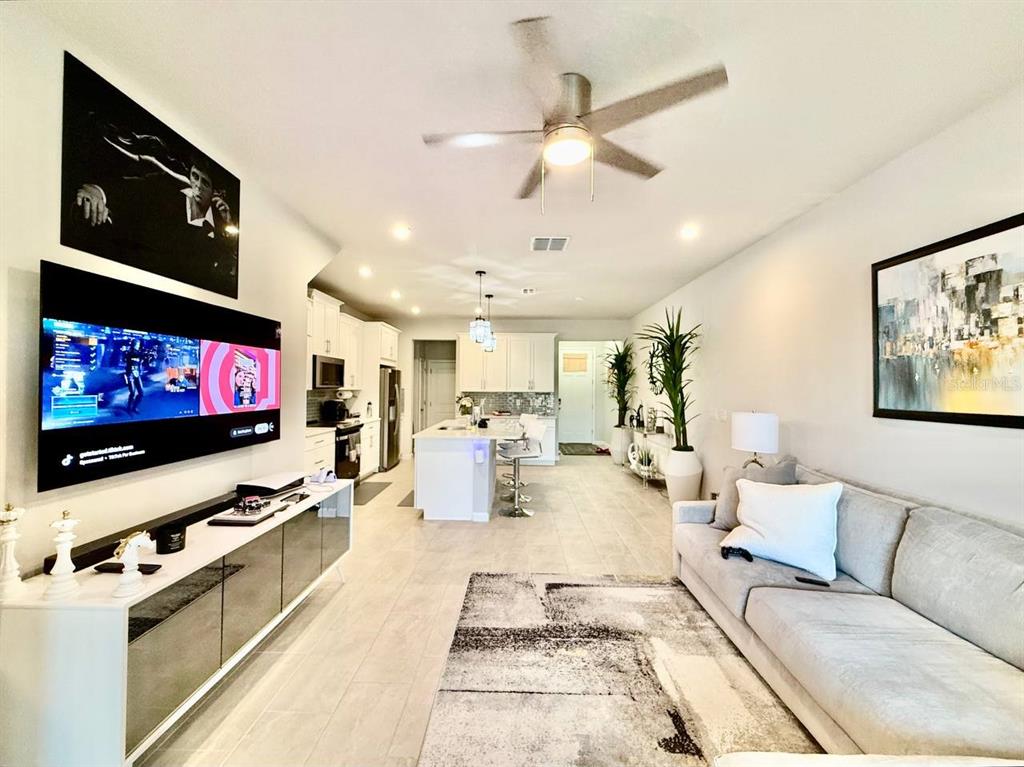 8319 Wildflower Glen Avenue Odessa, FL 33556 - Photo 12 of 34 a living room with furniture and a flat screen tv
