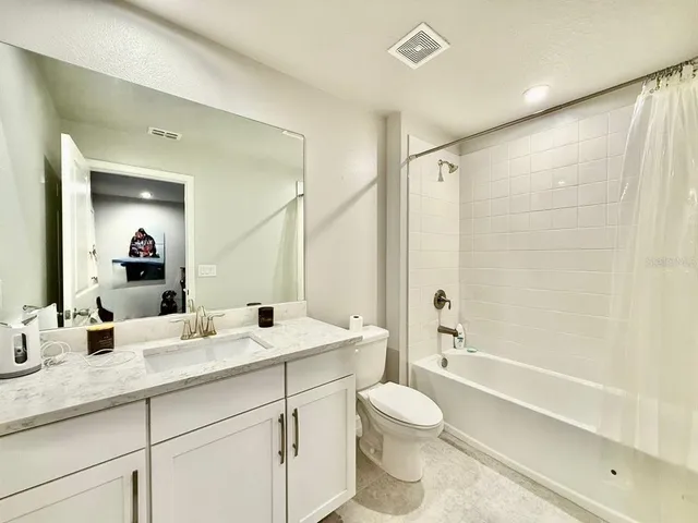 a bathroom with a double vanity sink toilet mirror and bathtub