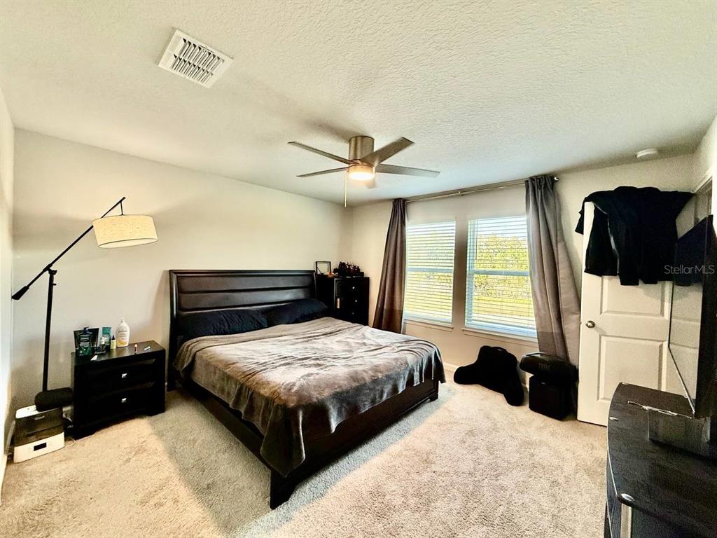 8319 Wildflower Glen Avenue Odessa, FL 33556 - Photo 22 of 34 a bedroom with a bed and a couch