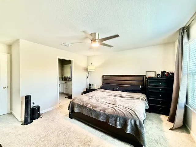 a bedroom with a bed and a ceiling fan