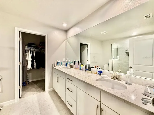 a spacious bathroom with a double vanity sink and mirror