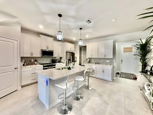 a kitchen with cabinets a sink and white appliances
