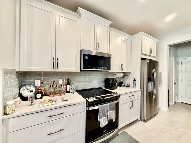 a kitchen with stainless steel appliances white cabinets and sink