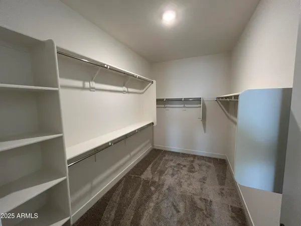 a view of walk in closet with empty racks