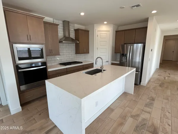 a large kitchen with stainless steel appliances granite countertop a sink a stove a refrigerator and cabinets