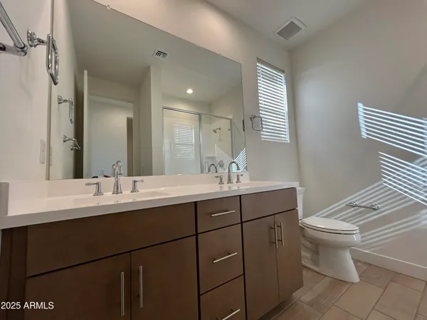 a bathroom with a double vanity sink toilet and a mirror