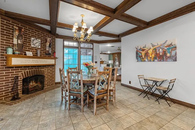 a kitchen with stainless steel appliances granite countertop a dining table chairs refrigerator and cabinets