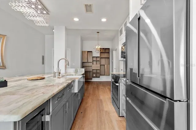 a kitchen with kitchen island a counter top space a sink stainless steel appliances and cabinets