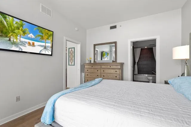 a bedroom with a bed and a painting on the wall