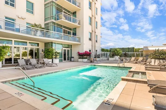 a view of a building with sitting area and swimming pool