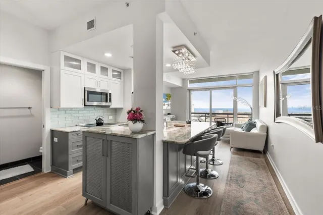 a view of living room kitchen with stainless steel appliances granite countertop furniture and a window