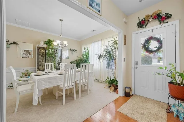 a view of a dining room and livingroom with furniture wooden floor a chandelier