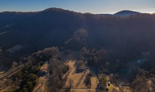 a view of a house with a mountain and a forest