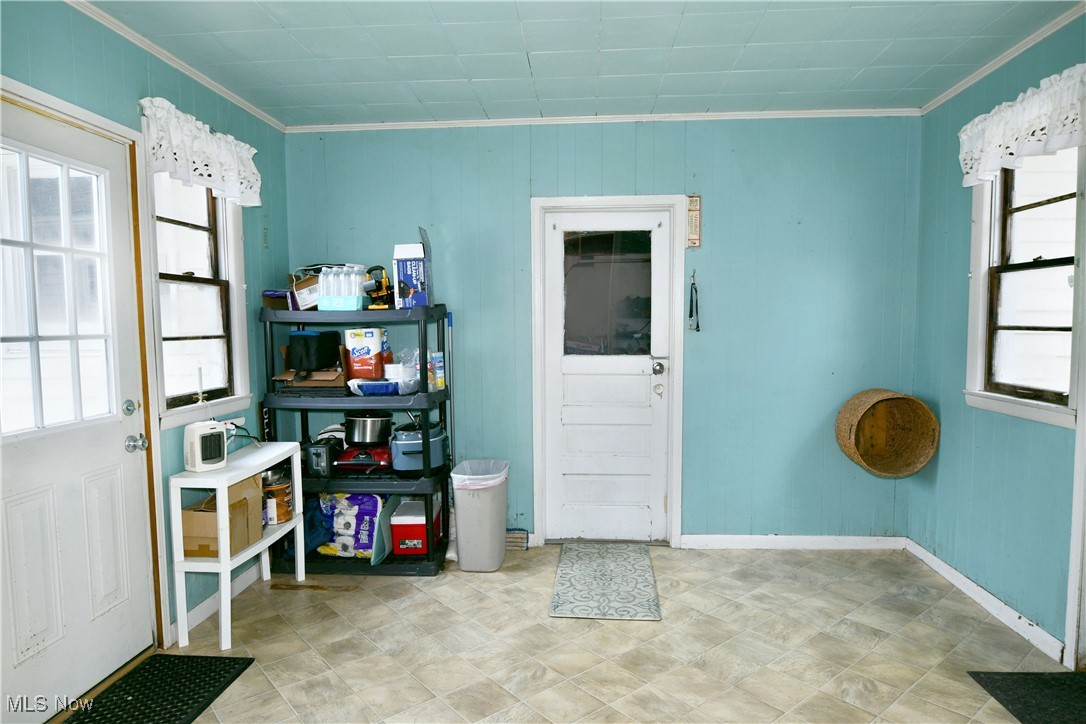 3224 Reeves Road Northeast Warren, OH 44483 - Photo 18 of 49 Entryway with light floors, wood walls, and crown molding