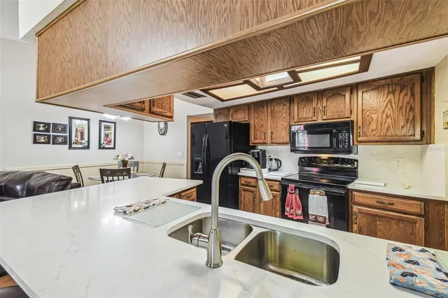 a kitchen with stainless steel appliances granite countertop a sink and a refrigerator