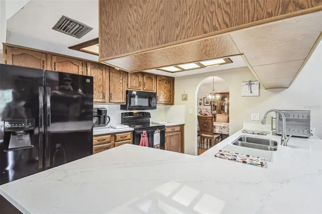 a kitchen with stainless steel appliances kitchen island granite countertop a refrigerator and a stove top oven