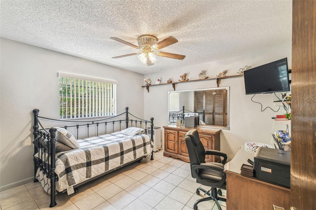 6938 Coronet Drive New Port Richey, FL 34655 - Photo 28 of 49 a bedroom with furniture and a window