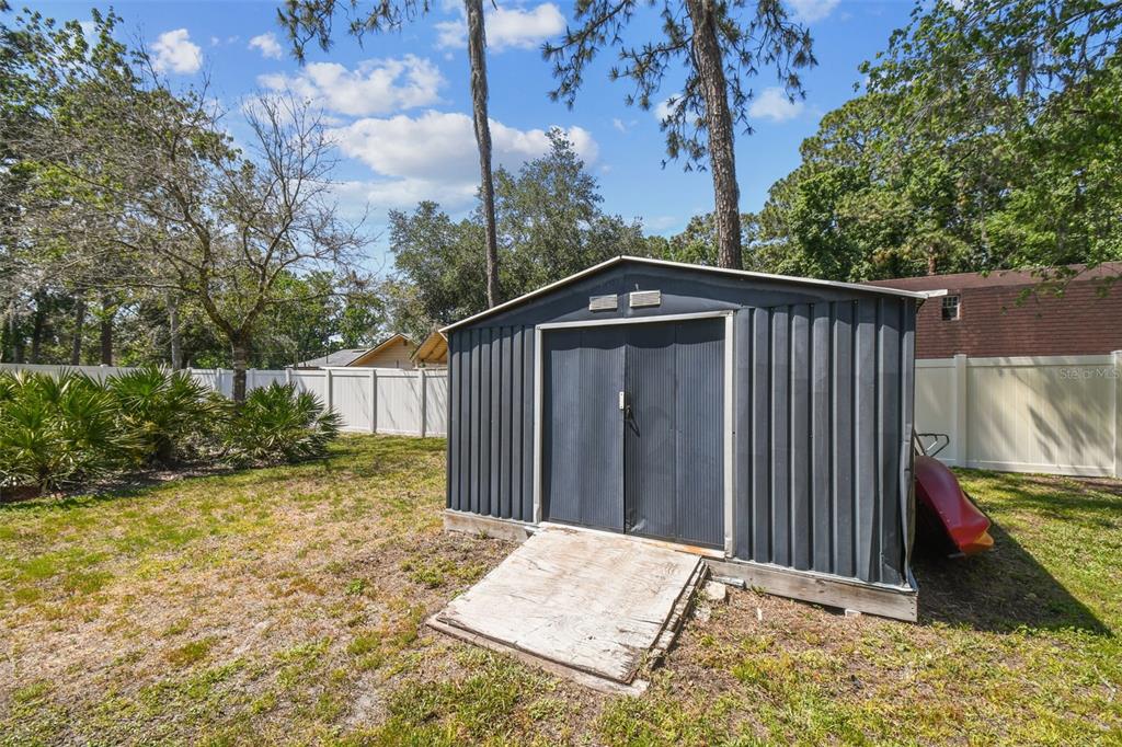 6938 Coronet Drive New Port Richey, FL 34655 - Photo 45 of 49 a backyard of a house with wooden fence