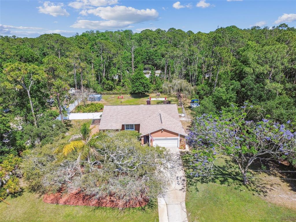 6938 Coronet Drive New Port Richey, FL 34655 - Photo 48 of 49 an aerial view of a house with a yard and lake view