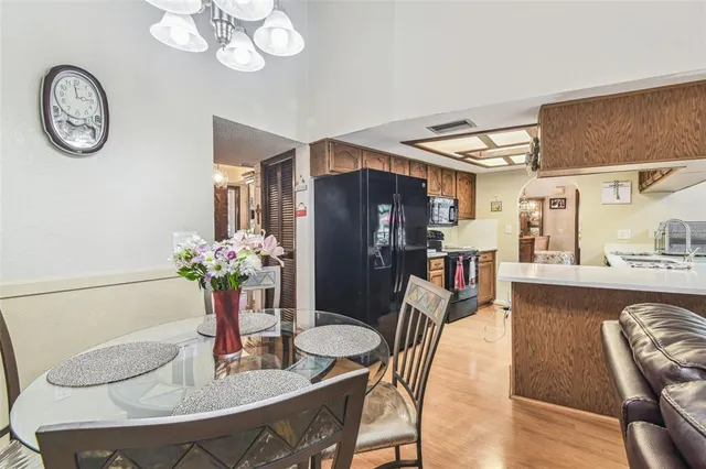 a dining room with furniture a potted plant and wooden floor